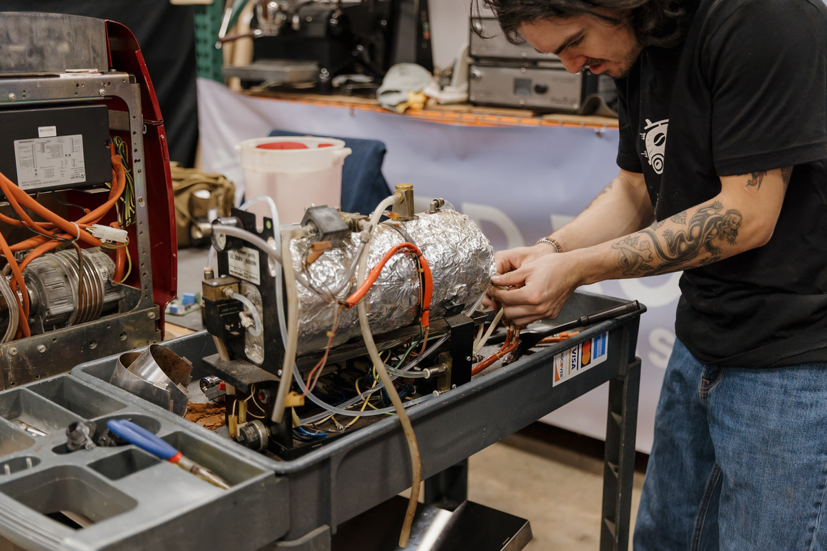 Espresso Medic technician repairing an espresso machine boiler in the workshop