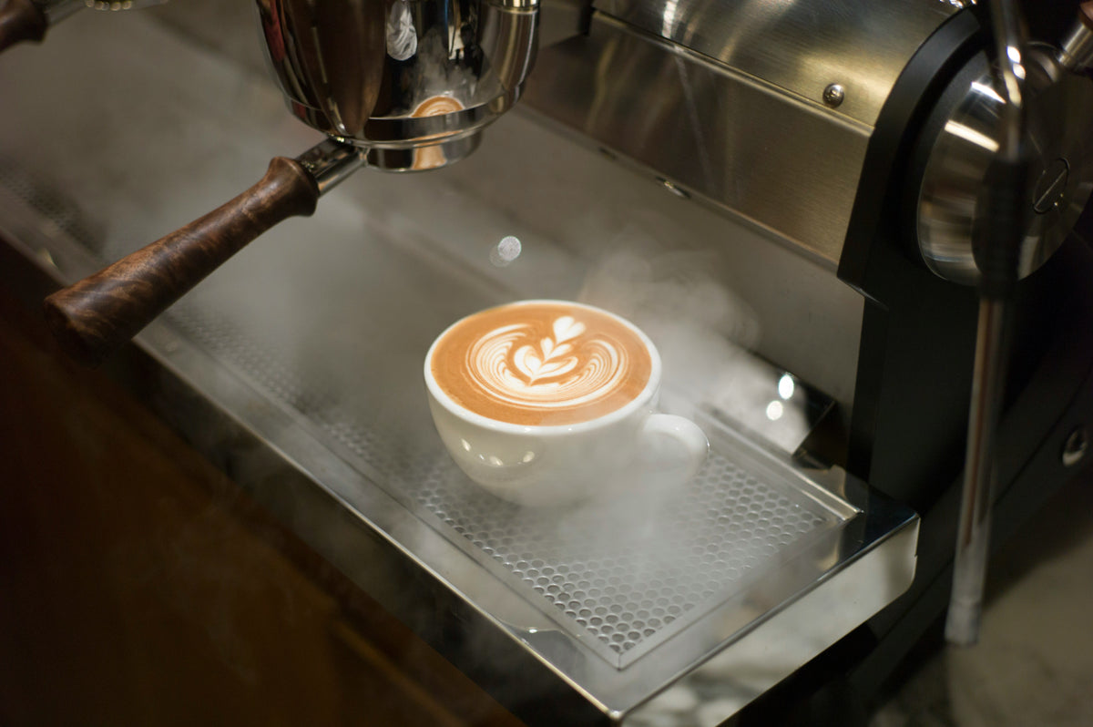 Latte art on an espresso machine's drip tray